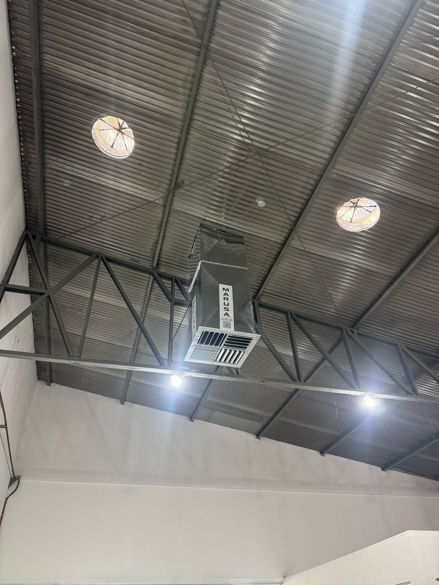 Duto de climatizador Marusa e exaustores eólicos no telhado de um galpão